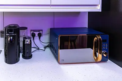 a microwave sitting on top of a counter next to a appliance at The Rockfield by Serene Stays Stylish 6BR near Anfield with Bar Virgin Media and Fast WiFi in Liverpool
