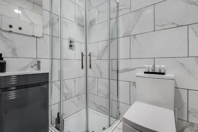 a bathroom with a shower and a toilet and a sink at The Rockfield by Serene Stays Stylish 6BR near Anfield with Bar Virgin Media and Fast WiFi in Liverpool