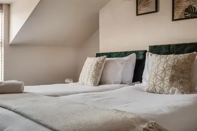 a bedroom with two beds with white sheets and pillows at The Rockfield by Serene Stays Stylish 6BR near Anfield with Bar Virgin Media and Fast WiFi in Liverpool