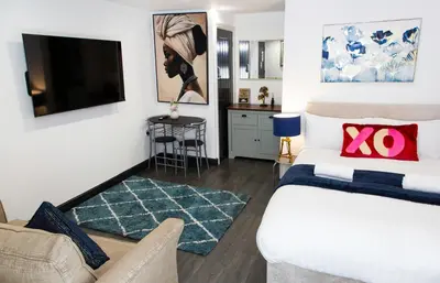 a bedroom with a bed and a living room at Snuggle Cove Apartments- Walton Road in Liverpool