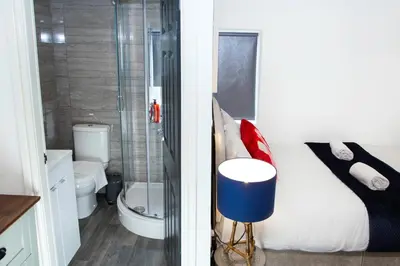 a bathroom with a bed and a shower and a toilet at Snuggle Cove Apartments- Walton Road in Liverpool
