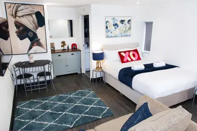 a bedroom with a bed and a living room at Snuggle Cove Apartments- Walton Road in Liverpool