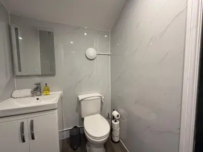 a white bathroom with a toilet and a sink at Snuggle Cove Apartments- Walton Road in Liverpool