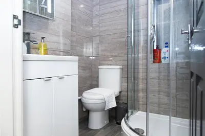 a bathroom with a toilet and a sink and a shower at Snuggle Cove Apartments- Walton Road in Liverpool