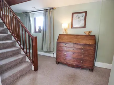 a room with a dresser and a staircase with a dresser at Stoneycross Cottage in Preston