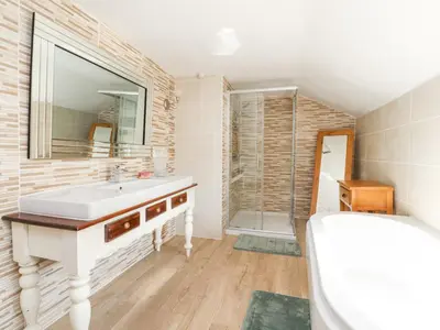 a bathroom with a sink and a mirror at Stoneycross Cottage in Preston