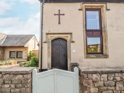 a church with a cross on top of a door at Stoneycross Cottage in Preston