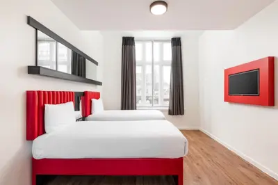 a hotel room with two beds and a tv at Tune Hotel Liverpool in Liverpool