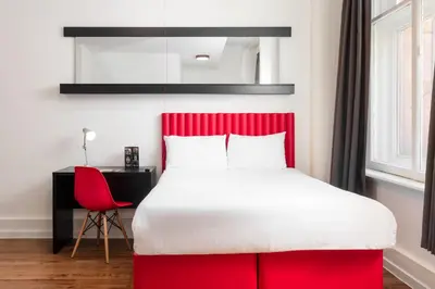 a bedroom with a red bed and a red chair at Tune Hotel Liverpool in Liverpool