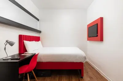 a bedroom with a bed and a desk with a computer at Tune Hotel Liverpool in Liverpool
