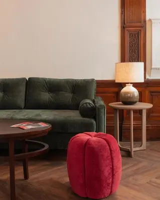 a living room with a couch and a red ottoman at Tune Hotel Liverpool in Liverpool
