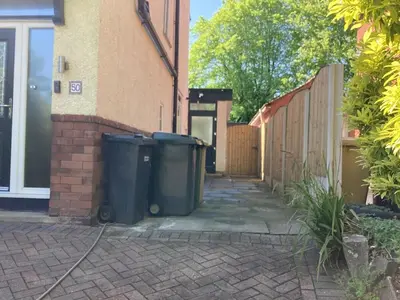 two trash cans are sitting outside of a house at Golf view lodge in Lostock