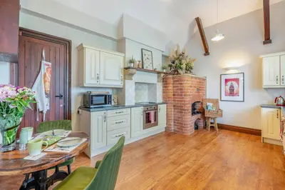 a kitchen and dining room with a brick fireplace at 1 Bed in Weeton oc-c32015 in Great Singleton