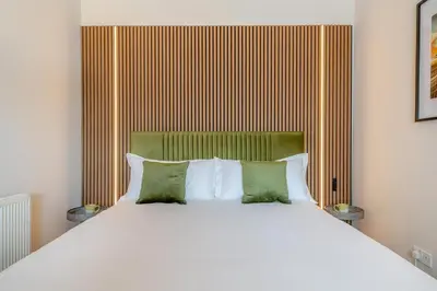 a bedroom with a large white bed with green pillows at 1 Bed in Weeton oc-c32015 in Great Singleton