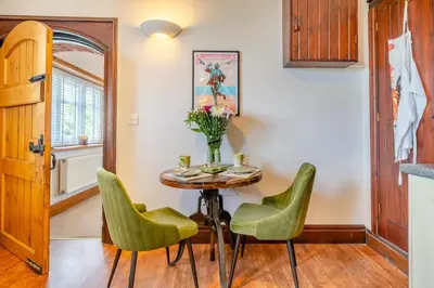 a dining room with a table and green chairs at 1 Bed in Weeton oc-c32015 in Great Singleton