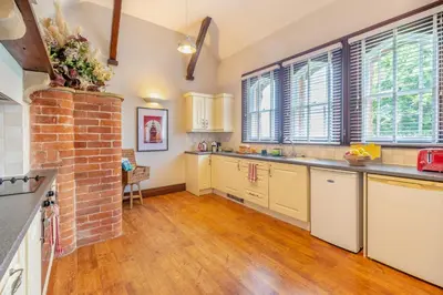 a kitchen with white cabinets and a brick wall at 1 Bed in Weeton oc-c32015 in Great Singleton