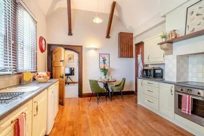 a kitchen with white cabinets and a table with chairs at 1 Bed in Weeton oc-c32015 in Great Singleton
