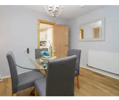 a dining room with a glass table and chairs at Willow Cottage Haverigg Millom in Haverigg