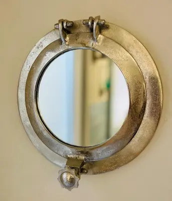 a bronze mirror hanging on a wall at Willow Cottage Haverigg Millom in Haverigg