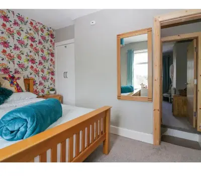 a bedroom with a bed and a mirror at Willow Cottage Haverigg Millom in Haverigg