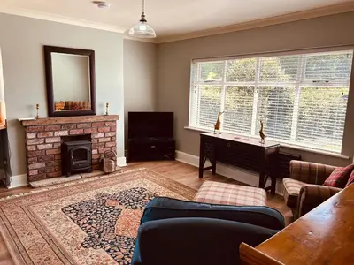a living room with a fireplace and a mirror at Oaken Fields, Waddington, Clitheroe in Waddington