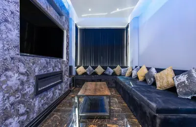 a living room with a black couch and a table at New Mixies Manor in Blackpool