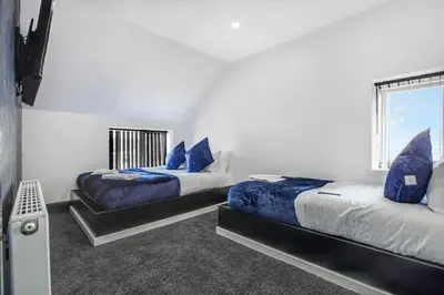 two beds with blue pillows in a room at New Mixies Manor in Blackpool