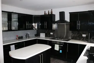 a kitchen with black cabinets and a white counter top at 80 Anfield house in Liverpool