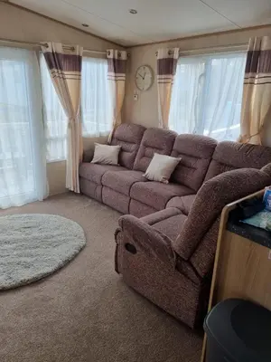 a living room with a couch and a clock at Private Caravan to Hire - Marton Mere Haven Holiday Village in Blackpool