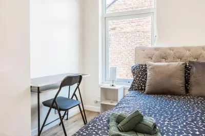 a bedroom with a desk and a bed and a chair at Free Parking, 4 Bed, 2 Bath House, Long Term Stay Savings, Contractors, Near Anfield in Liverpool