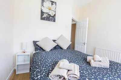 a bedroom with a bed with towels on it at Free Parking, 4 Bed, 2 Bath House, Long Term Stay Savings, Contractors, Near Anfield in Liverpool