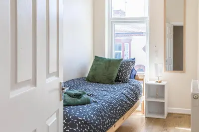a bedroom with a bed with blue sheets and a window at Free Parking, 4 Bed, 2 Bath House, Long Term Stay Savings, Contractors, Near Anfield in Liverpool