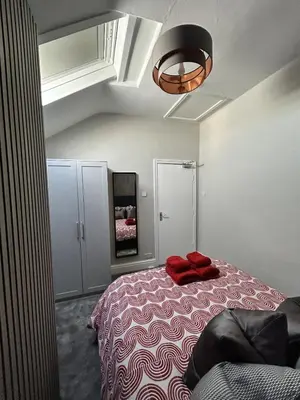 a bedroom with a bed with red towels on it at Sunny St Annes Apartment in Lytham St Annes