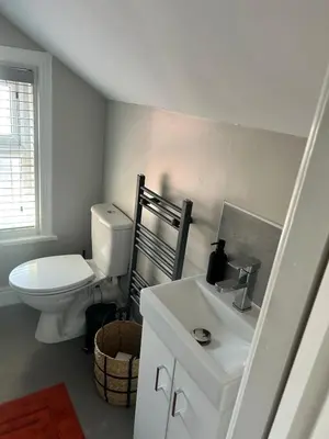 a white bathroom with a toilet and a sink at Sunny St Annes Apartment in Lytham St Annes