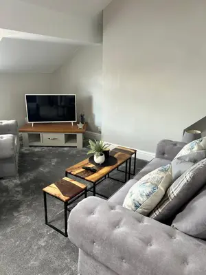 a living room with two couches and a flat screen tv at Sunny St Annes Apartment in Lytham St Annes