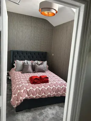 a bedroom with a bed with two red shirts on it at Sunny St Annes Apartment in Lytham St Annes
