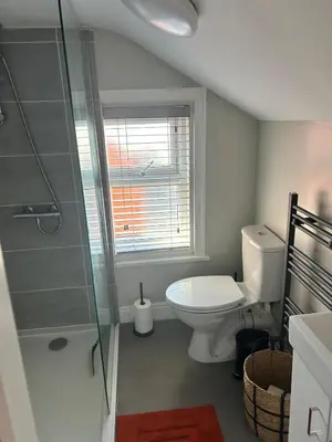 a bathroom with a toilet and a glass shower at Sunny St Annes Apartment in Lytham St Annes