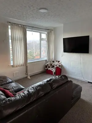 a living room with a couch and a flat screen tv at Cozy apt with good location in Garstang