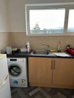a kitchen with a sink and a washing machine at Cozy apt with good location in Garstang