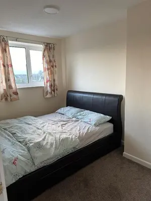 a bed in a bedroom with a window at Cozy apt with good location in Garstang