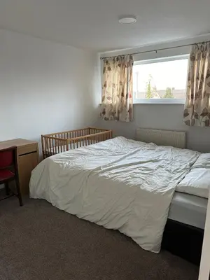 a bedroom with a white bed and a window at Cozy apt with good location in Garstang
