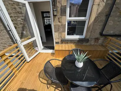 a black table and chairs on a wooden deck at The Hideaway - 2-Bedroom Apartment with outdoor terrace & free parking in Lancaster