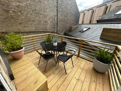 a patio with a table and chairs on a balcony at The Hideaway - 2-Bedroom Apartment with outdoor terrace & free parking in Lancaster