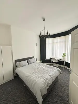 a bedroom with a large bed and a desk at Cozy Double Room with 5 Minute Walk to Anfield Stadium ideal for Matchdays in Liverpool