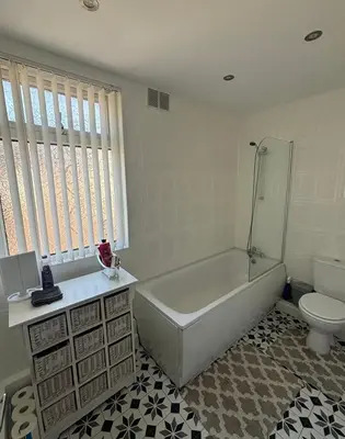 a white bathroom with a tub and a toilet at Cozy Double Room with 5 Minute Walk to Anfield Stadium ideal for Matchdays in Liverpool