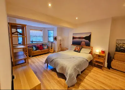 a bedroom with a bed and a living room at Liverpool Georgian Quarter Apartment in Liverpool