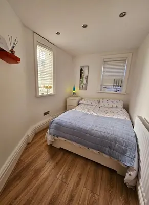a bedroom with a bed and two windows at Liverpool Georgian Quarter Apartment in Liverpool