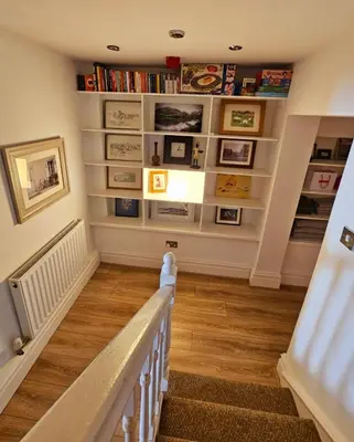 a staircase with bookshelves in a home with a stair case at Liverpool Georgian Quarter Apartment in Liverpool