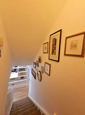 a staircase with pictures on the walls of a home at Liverpool Georgian Quarter Apartment in Liverpool