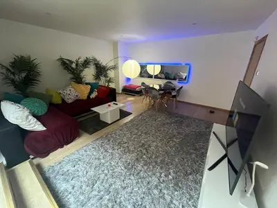 a living room with a couch and a fish tank at 2 bed apartment Liverpool city centre in Liverpool